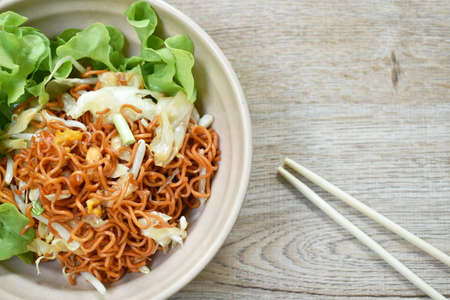 fried instant noodles with cabbage and egg in soybean sauce on bowl