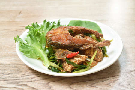 deep fried slice striped snake head fish with ginger and celery on dishの写真素材