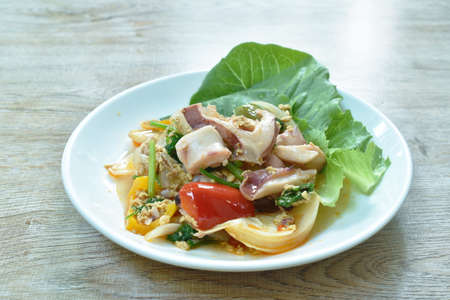 stir fried squid in yellow curry and egg on plateの写真素材