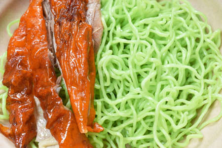 Chinese jade noodles topping slice roasted duck dressing sweet soy sauce on bowlの写真素材