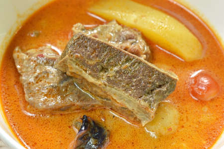beef curry with slice potato and onion in bowlの写真素材
