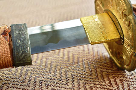 Japanese samurai sword blade or katana on bamboo mat background