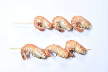 grilled shrimp with salt stabbing wooden stick on white backgroundの写真素材