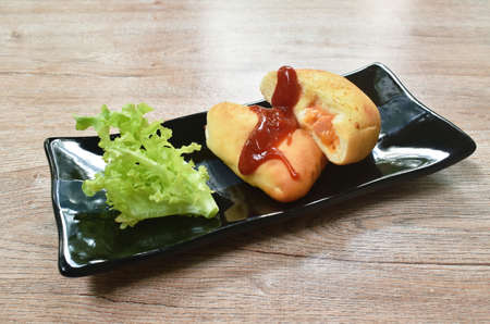 bread stuffed smoked chicken sausage and cheese dressing ketchup with vegetable on plateの写真素材