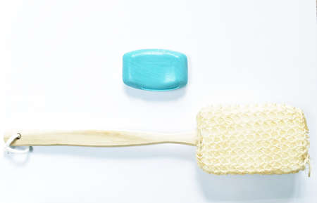 loofah body scrub with wooden handle and blue soap bar on white backgroundの写真素材