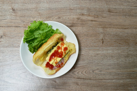 baked Danish bread stuffed slice pork bacon with mashed spinach and cheese dressing ketchup eat couple fresh lettuce vegetable salad on plateの写真素材