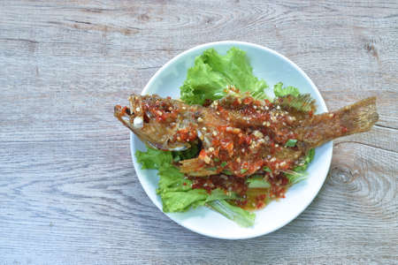 batter fried red grouper fish dressing spicy and sweet sauce on plate