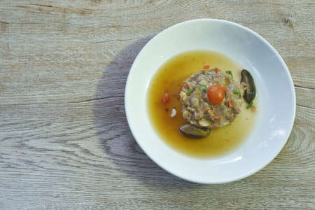 steamed chop pork topping salty egg yolk with mushroom in gravy sauce on plate