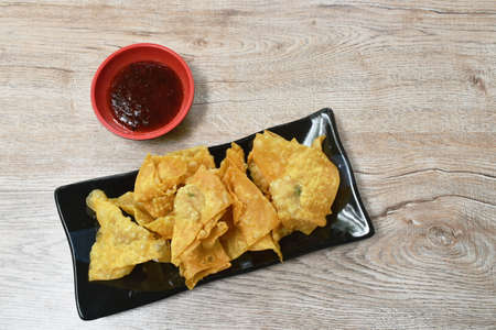crispy fried dumpling paste stuffed chop pork dipping sweet chili sauce on plateの写真素材
