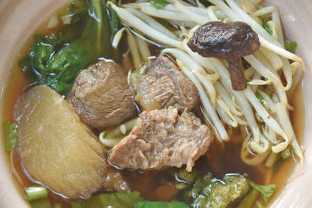 braised beef meat with bean sprout topping mushroom  in brown soup on bowl