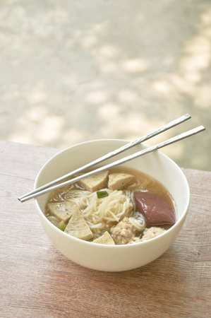Vietnamese rice noodles or Pho with slice sausage and chop pork in soup on bowl