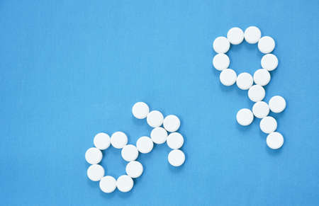white tablet medicine arranging male and female symbol on blue backgroundの写真素材