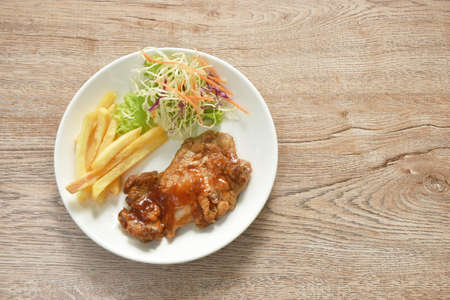 grilled chicken black pepper steak dressing spicy sauce with French fries and salad on plateの写真素材