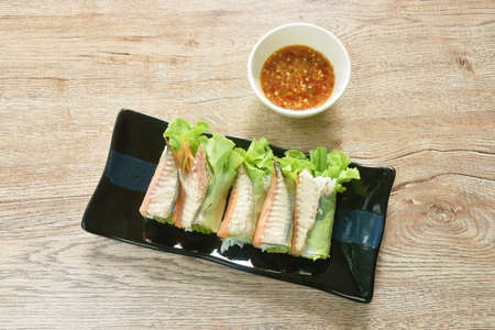 roll flour stuffed mackerel fish and vegetable dipping with spicy chili sauce on plateの写真素材