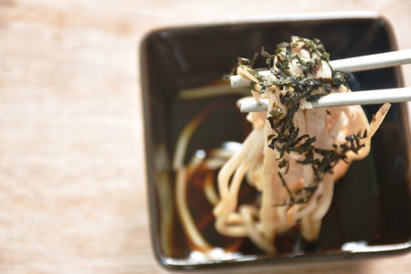 boiled cold yakisoba Japanese noodles topping dry slice seaweed on plate dipping soy sauceの写真素材