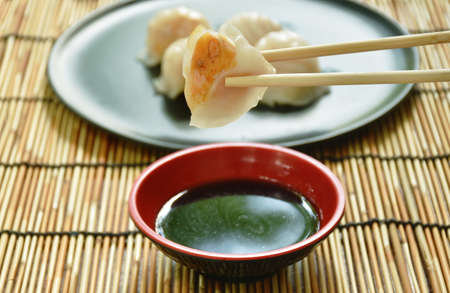 Ha Kao or white dumpling stuffed shrimp and pork on plate dipping soy sauceの写真素材