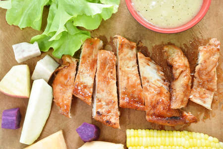 grilled chicken steak with slice variety fresh fruit arranging on chopping blockの写真素材