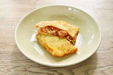 fried mashed pork with tomato and onion stuffed in Thai egg omelets on dishの写真素材