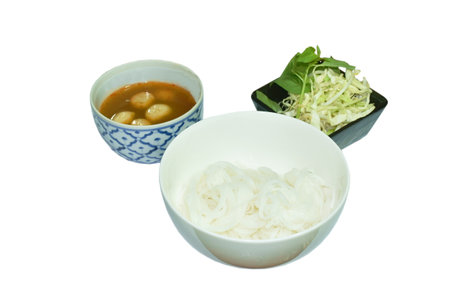rice noodles on bowl with spicy  fish curry sauce and fresh vegetable