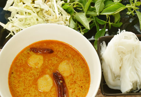 rice noodles on bowl with spicy  fish curry sauce and fresh vegetable