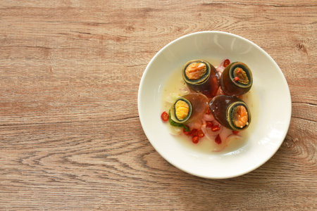 boiled salty black preserved egg half cut with slice shallot salad on plate