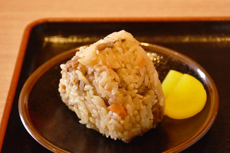 rice ball stuffed salmon with slice pickled radish on plateの写真素材