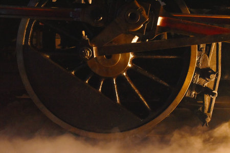 steam locomotive iron wheel with smoke floating on railway in nightの写真素材