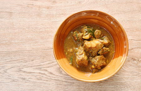 spicy fried pork bone with curry and basil leaf on bowlの写真素材