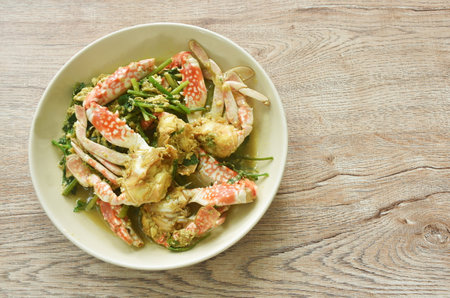 stir fried swimmer crab in yellow curry and egg on plateの写真素材