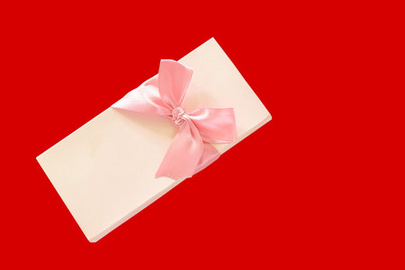 ribbon roll pink gift box on red backgroundの写真素材