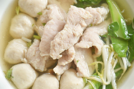 boiled soft slice pork and ball in clear soup on bowl eat couple plain rice