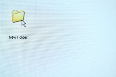 arrow computer mouse pointer icon to yellow new folder on white LCD screenの写真素材