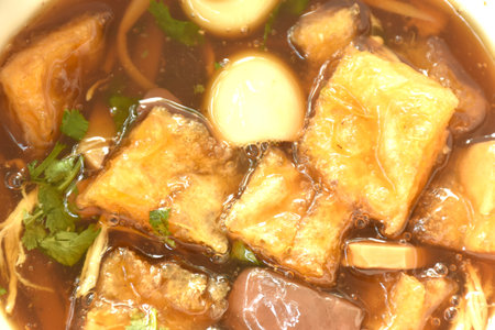 braised fish maw with bamboo shoot topping boiled egg in red gravy soup on bowlの写真素材