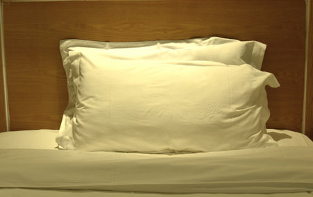 two pillow and  blanket opened for one people onsingle bed in nightの写真素材