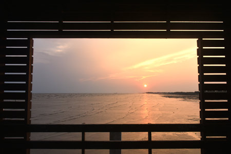 landscape of sea in sunset from wooden frame of pavilion in Thailand