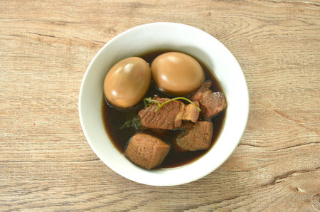 boiled egg with fat pork land tufu in herb brown soup on bowlの写真素材