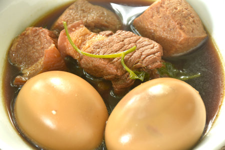 boiled egg with fat pork land tufu in herb brown soup on bowlの写真素材