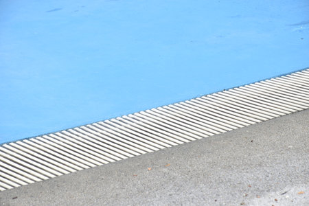 water flowing to edge of blue tile swimming pool