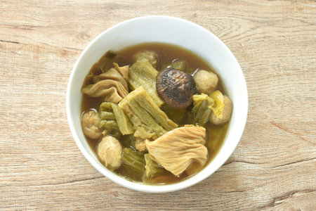 boiled pickled cabbage and bitter cucumber with tofu topping black mushroom in Chinese herb soup on bowlの写真素材