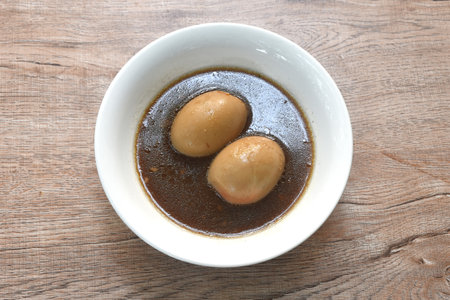 boiled egg stew in Chinese herb brown pork bone soup on bowlの写真素材
