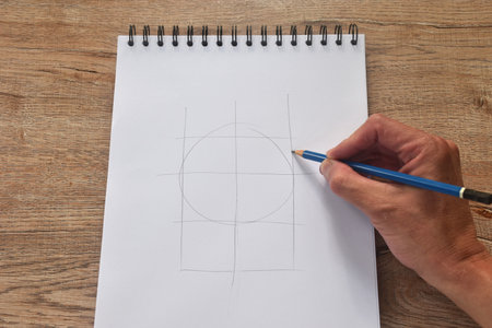 hand drawing outline by blue pencil in sketchbook binding on deskの写真素材