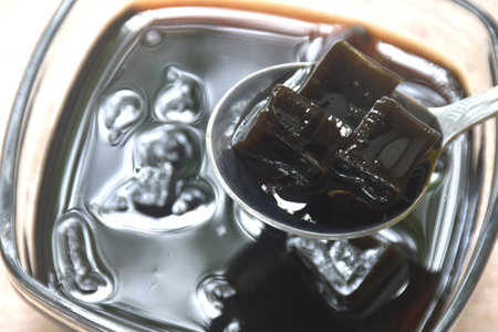 black grass jelly Chinese cold sweetmeat in syrup in glass bowlの写真素材