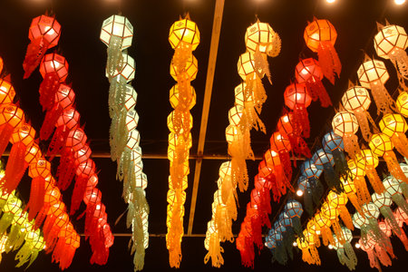 colorful paper Eastern Thai lantern style with electric lamp hanging on rooftop in nightの写真素材