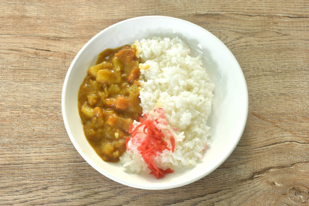 pork with potato and carrot in Japanese curry with rice topping slice red pickled cabbage on plateの写真素材
