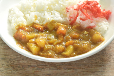 pork with potato and carrot in Japanese curry with rice topping slice red pickled cabbage on plateの写真素材