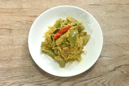 stir fried spicy mixed glass noodles with vegetables and pork belly in Thai northern style on plateの写真素材
