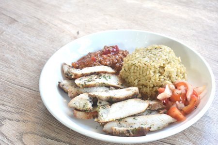 grilled slice chicken black pepper steak dressing tomato sauce with fried rice on plateの写真素材