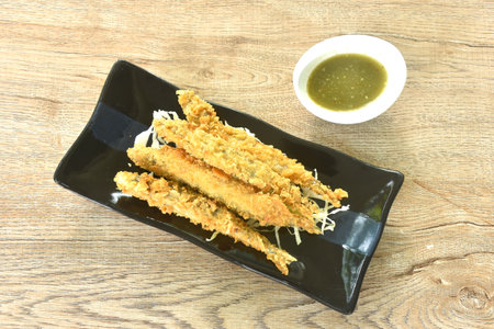 deep fried capelin fish with chop cabbage on plate dipping spicy seafood sauceの写真素材