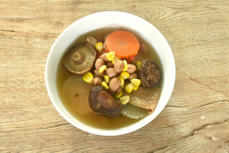 boiled corn with peanut and slice vegetable topping mushroom in herb soup on bowlの写真素材