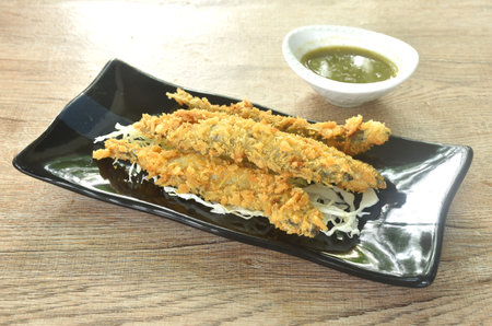 deep fried capelin fish or Shishamo Japanese food with chop cabbage on plate dipping spicy seafood sauceの写真素材